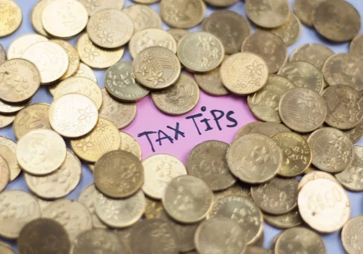 A pile of coins with the word tax tips written on it.